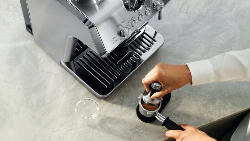 De'Longhi Arte Metal Pro Cold Brew coffee machine in stainless steel, featuring cold extraction, grinder, steam wand, and pre-set recipes.