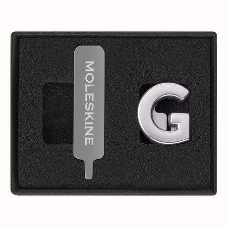 Stylish Moleskine Pins G Silver letters for personalizing notebooks with initials or messages, crafted from high-quality zinc alloy.