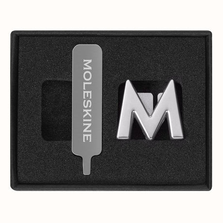 Stylish Moleskine Pins M Silver for personalizing notebooks with initials or quotes, made of durable zinc alloy.