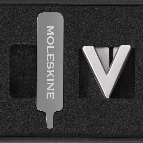 Elegant silver Moleskine Pins V for personalizing notebooks with letters, initials, or quotes on the elastic closure.