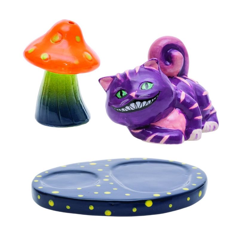 Whimsical salt and pepper shakers shaped like a mad cat and mushroom, with a stylish black tray featuring green spots.