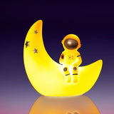 Moon Astronaut Table Lamp featuring a cozy astronaut on a crescent moon, providing warm LED light for children's spaces.