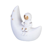 Moon Astronaut Table Lamp with an astronaut on a crescent moon, providing a warm glow for kids' bedtime stories and decor.