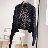 Stylish black Joanna Crochet Shrug in premium cotton, featuring intricate crochet design for elegant layering.