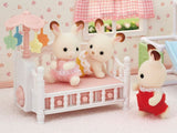 Crib with mobile featuring triplet beds, spinning decorations, and storage drawers for imaginative play.