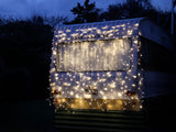 Curtain lights with 400 warm white LEDs on a 2 x 2M black cable, ideal for indoor and outdoor ambient decoration.
