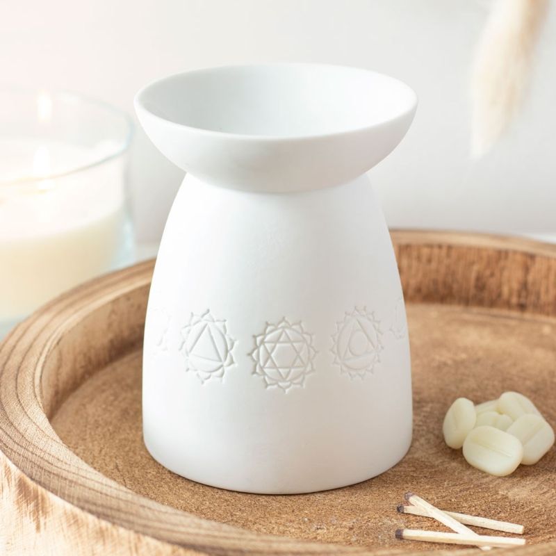 Elegant white ceramic oil burner featuring seven chakra symbols, perfect for aromatherapy and enhancing relaxation at home.