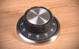 Sleek Safe Kitchen Timer resembling a combination lock, magnetically attaches to surfaces for easy access and precision cooking.