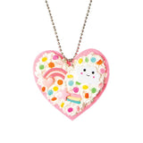 Colorful DIY heart necklace kit for kids, featuring pink felt pendant, Deco Cream, sprinkles, and charm accessories.