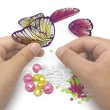 Colorful DIY mobile kit featuring 65+ glittery wings, craft materials, and glow-in-the-dark elements for creative kids.