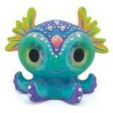 Colorful figurine painting kit featuring two fantasy creatures, paint, brushes, rhinestones, and glitter for creative fun.