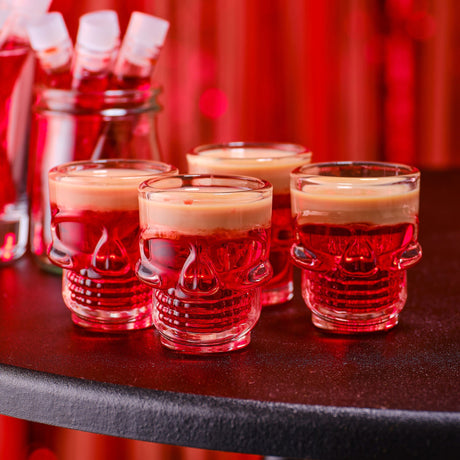 Set of 4 Halloween skull shot glasses, 7cm tall, perfect for spooky parties and eco-friendly celebrations.