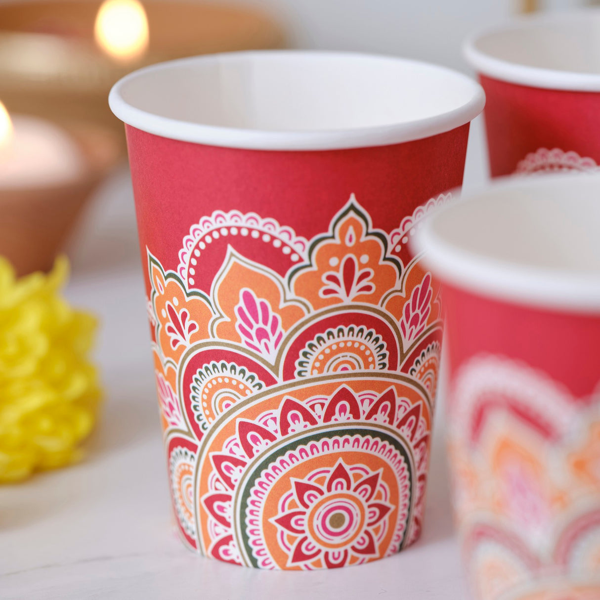 Vibrant red 9oz paper cups with intricate rangoli patterns, perfect for stylish Diwali celebrations and eco-friendly gatherings.