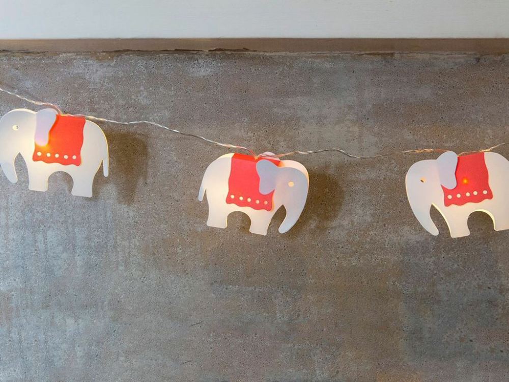 Whimsical fairy lights with 10 elephant designs in vibrant red blankets, perfect for kids' rooms and festive decor.
