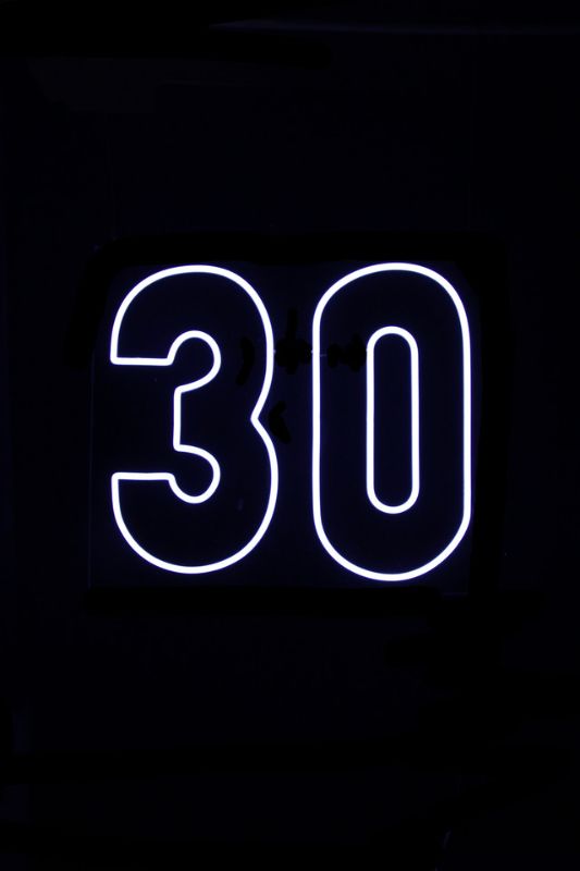 Neon LED sign displaying '30' in white, ideal for birthdays and celebrations, lightweight with easy installation.