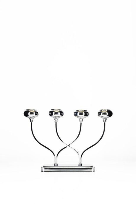 Stylish silver candle holder with four arms for candles, perfect for creating a warm ambiance in any room.