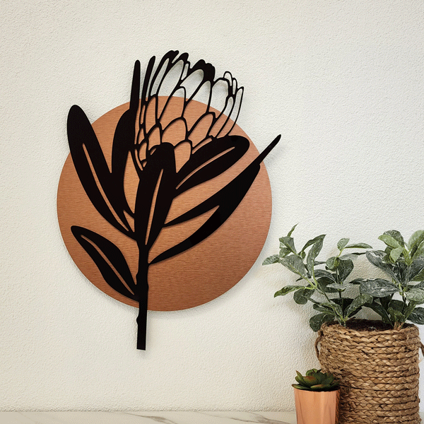 Stunning wall art featuring a gloss black Protea design within a brushed copper circle, perfect for modern decor.