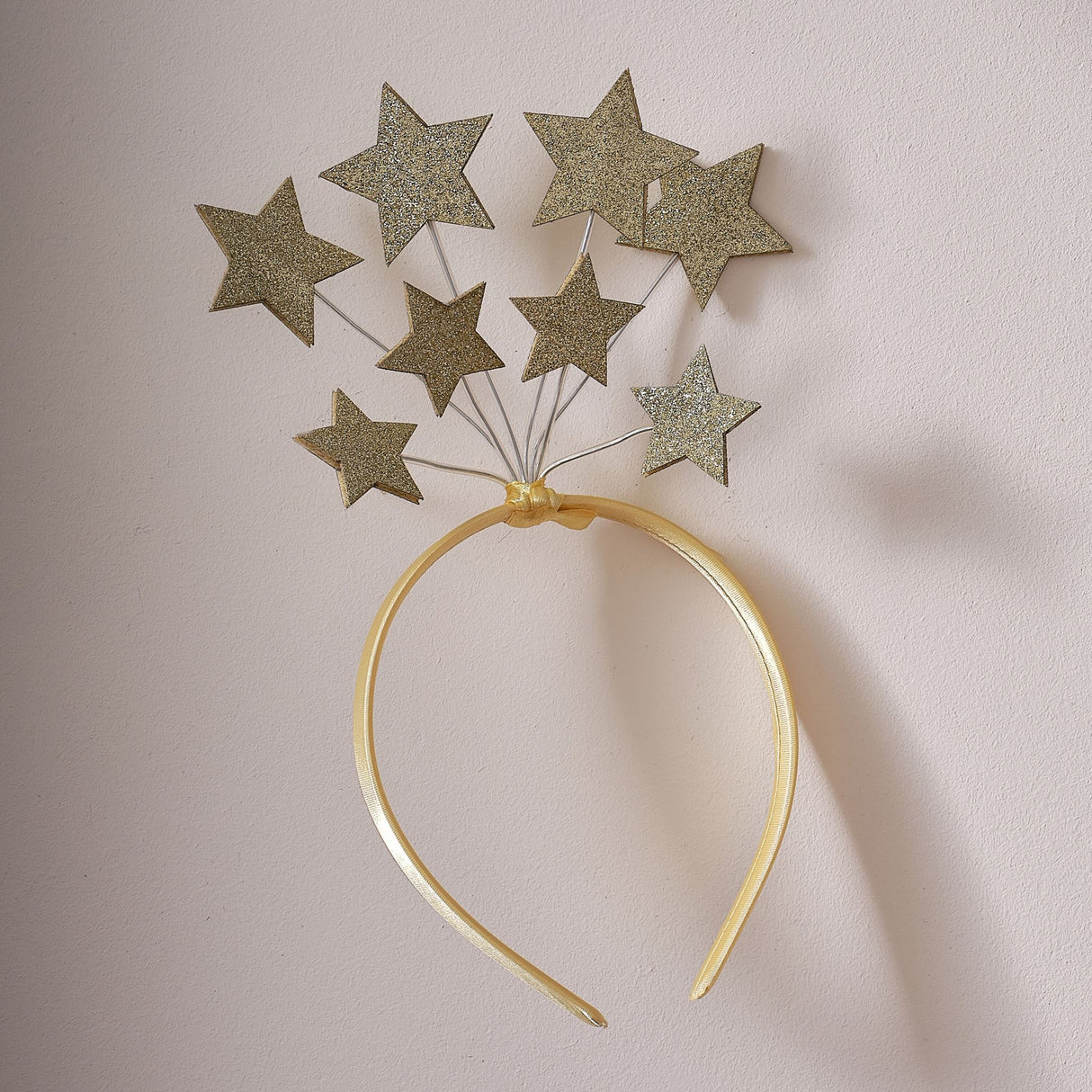 Gold satin headband adorned with eight glittering stars, perfect for festive celebrations and imaginative play.