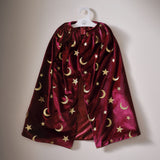 Burgundy velvet magician cape adorned with gold stars and moons, perfect for imaginative play or Halloween costumes.