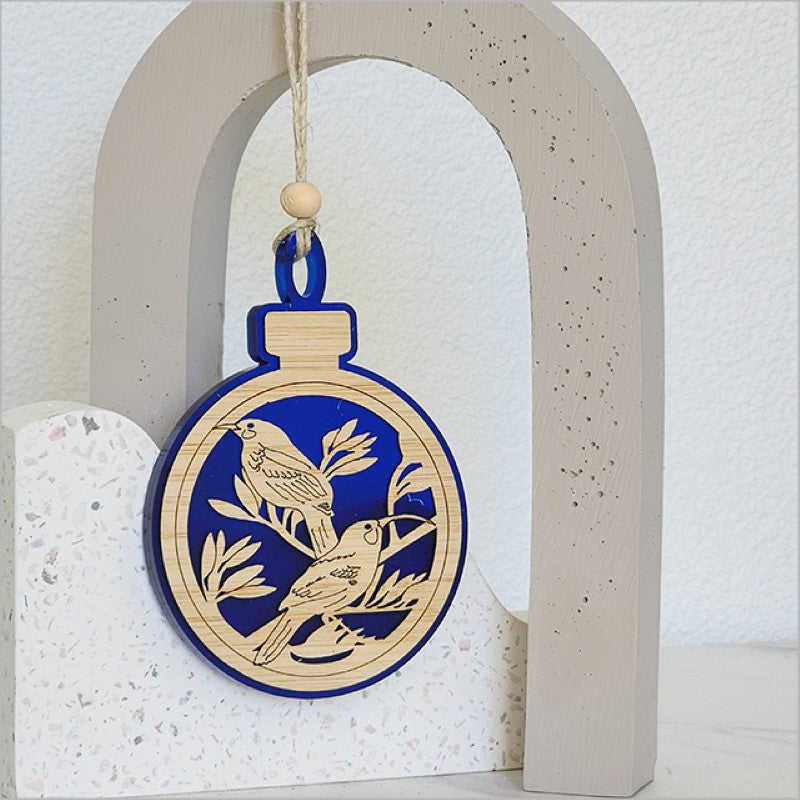Blue satin acrylic hanging ornament shaped like a Huia bird, perfect for festive decor and gifting.