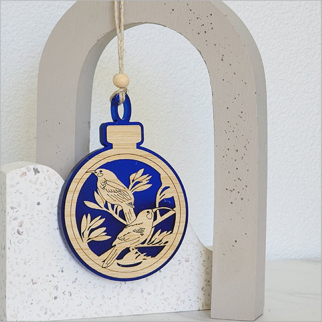 Blue satin acrylic hanging ornament shaped like a Huia bird, perfect for festive decor and gifting.