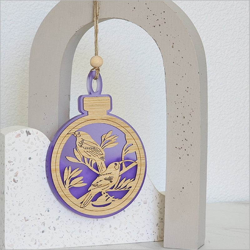 Elegant purple satin acrylic bauble ornament featuring a Huia bird design, perfect for holiday decor or gifting.