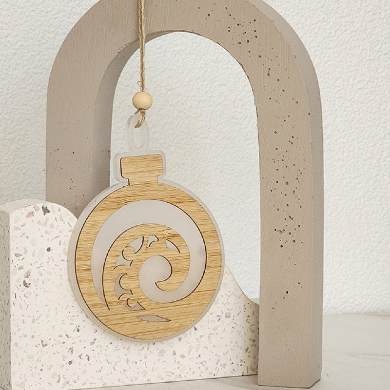 White satin acrylic hanging ornament featuring a Koru design and bamboo accent, ideal for holiday decor or gifting.