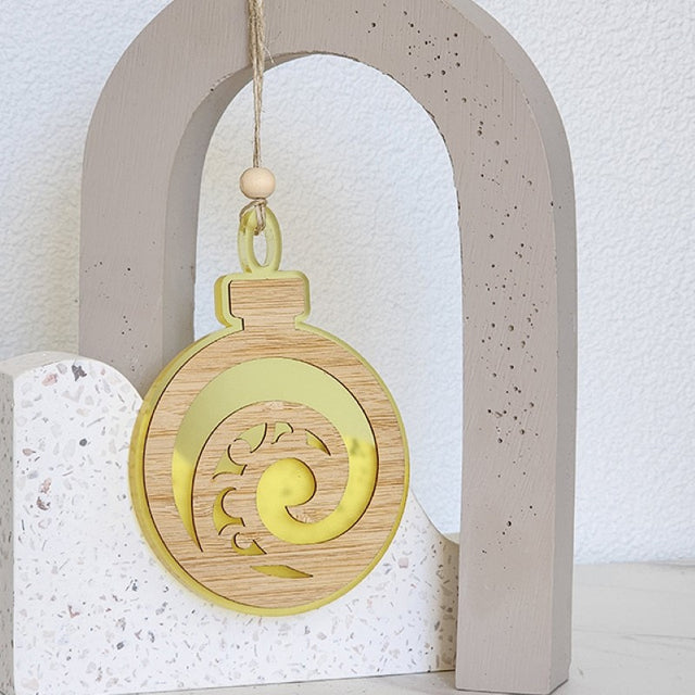 A vibrant yellow acrylic Koru ornament, beautifully laser cut, perfect for hangings and festive decor.
