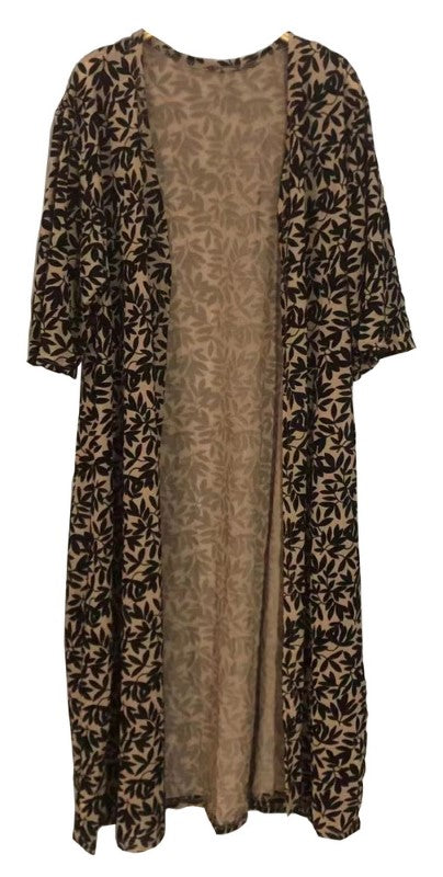 Camel velvet burnout cape drapes elegantly, featuring a versatile design suitable for various occasions and body types.