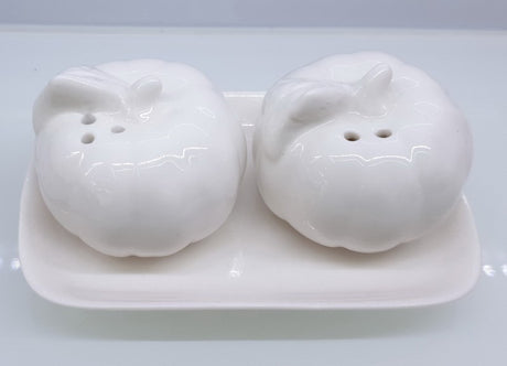 Charming ceramic pumpkin salt and pepper shakers, perfect for autumn-themed dining and festive occasions.