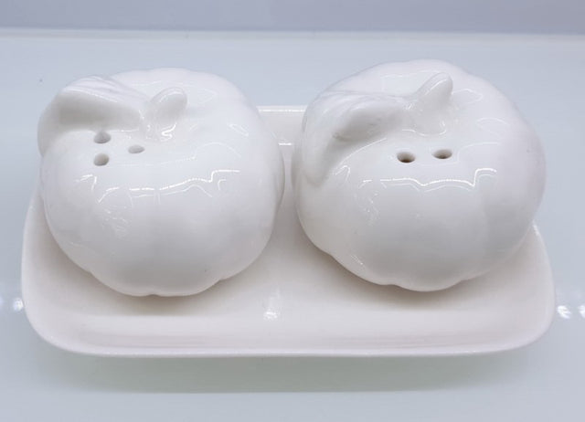 Charming ceramic pumpkin salt and pepper shakers, perfect for autumn-themed dining and festive occasions.