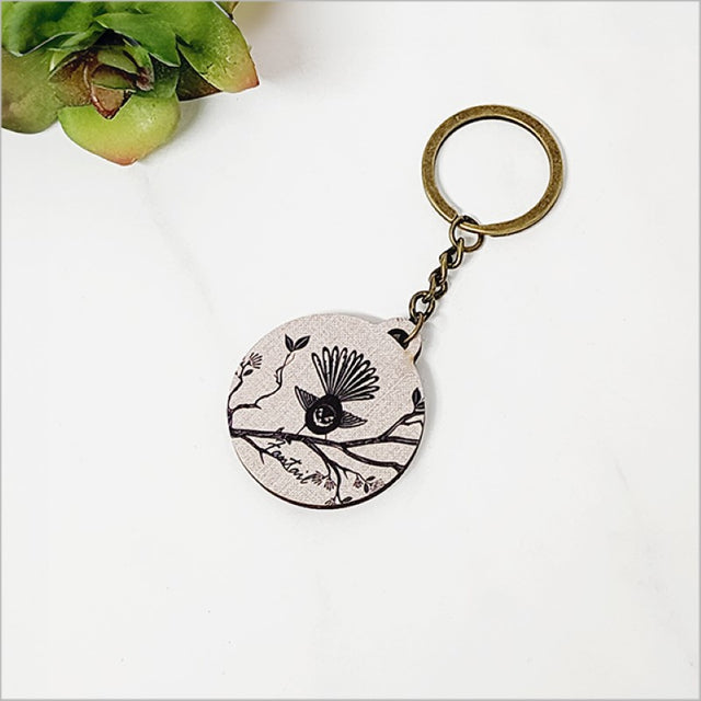Lightweight printed pine veneer keychain featuring a Fantail design, perfect for adding Kiwiana charm to your keys or bags.