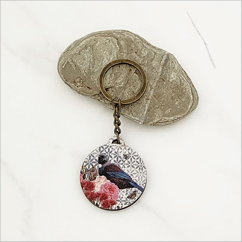Floral Tui keychain in lightweight pine veneer, showcasing Kiwiana design; 40mm diameter, 98mm total length.