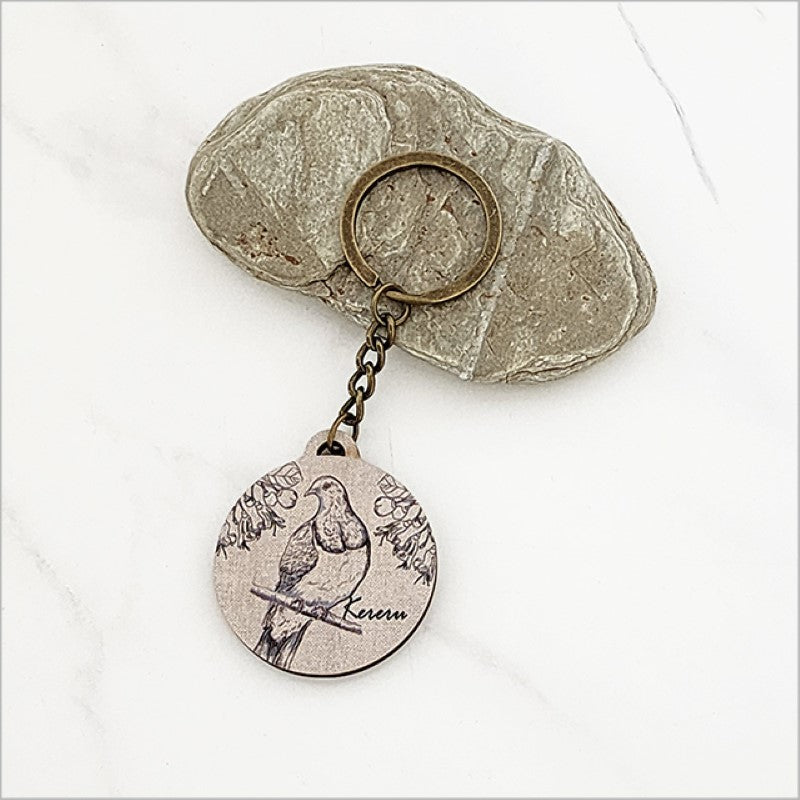 Lightweight pine veneer keychain featuring a Kereru and Puriri design, perfect for Kiwiana enthusiasts and ideal for gifts.