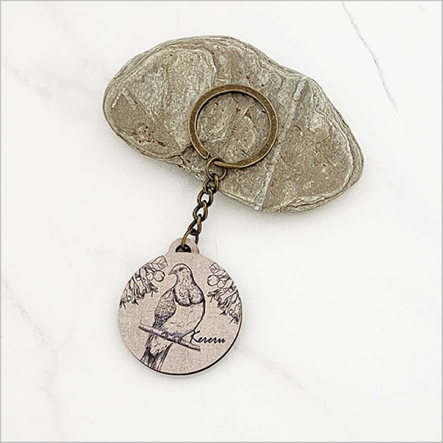 Lightweight pine veneer keychain featuring a Kereru and Puriri design, perfect for Kiwiana enthusiasts and ideal for gifts.