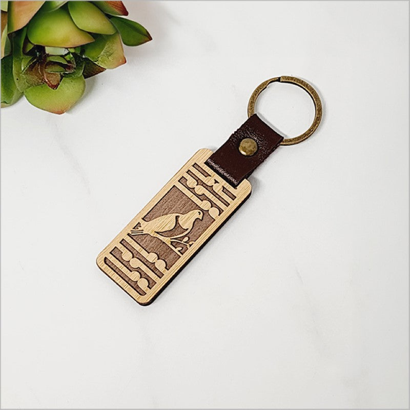 Bamboo keyring featuring a Kereru and Koru design, showcasing Kiwiana charm and eco-friendly craftsmanship.