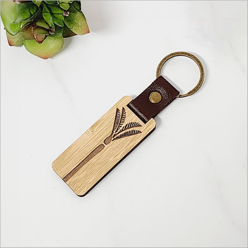 Laser cut bamboo keyring featuring an elegant Nikau palm design, showcasing Kiwiana style and eco-friendliness.