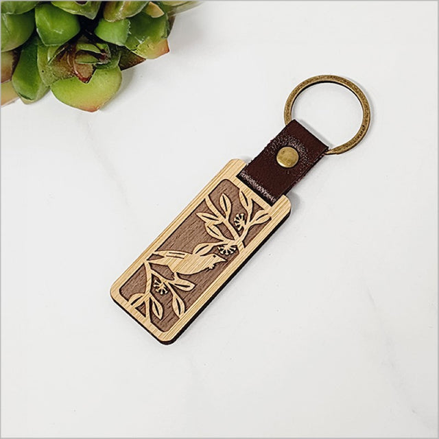 Eco-friendly bamboo keyring with intricate Tui design, lightweight and perfect for everyday use or as a unique gift.