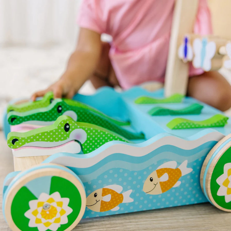 Vibrant wooden toddler walker with chomping alligators, promoting motor skills and imagination in young children.