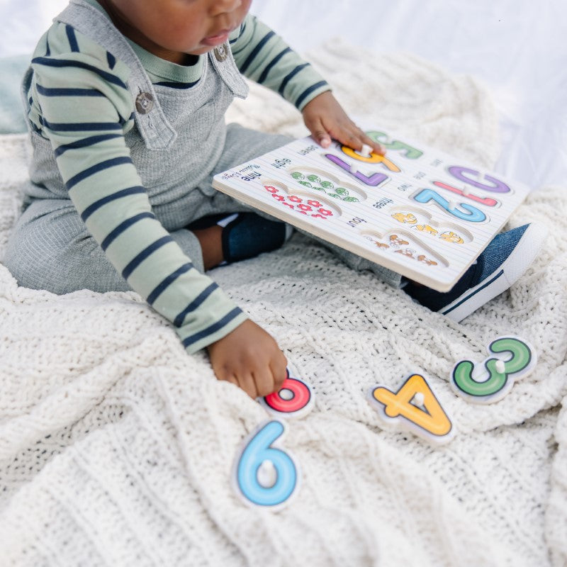 Colorful 10-piece number peg puzzle teaching toddlers numbers 0-9 with vibrant illustrations for counting and recognition skills.