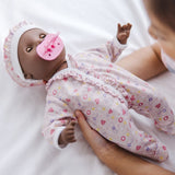 12-inch baby doll Gabrielle with dark skin, brown eyes, and removable outfit; perfect for nurturing and imaginative play.