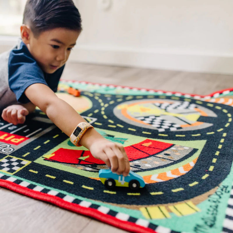 Colorful race track rug featuring pit stops and cheering crowds, includes four wooden cars for imaginative play.