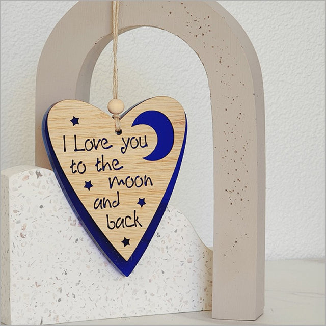 A blue satin acrylic heart and moon ornament, laser-cut bamboo frame, perfect for holiday decor and gifting.