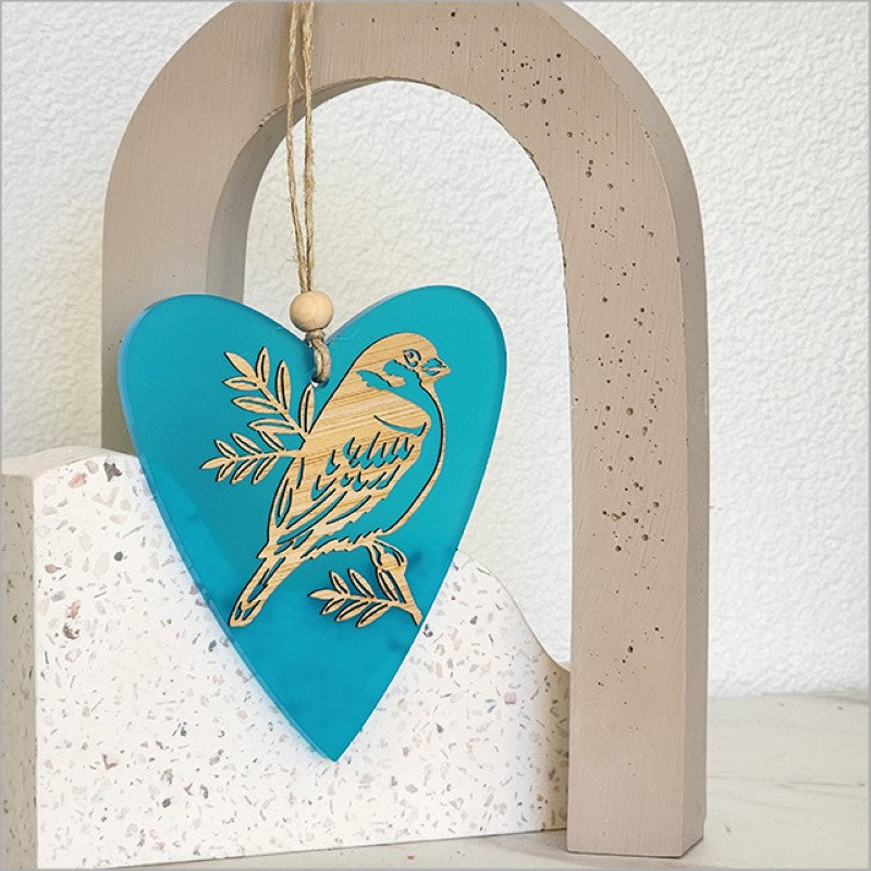 Teal satin acrylic heart ornament featuring sparrow and pihoihoi designs, perfect for home decor and gifting.