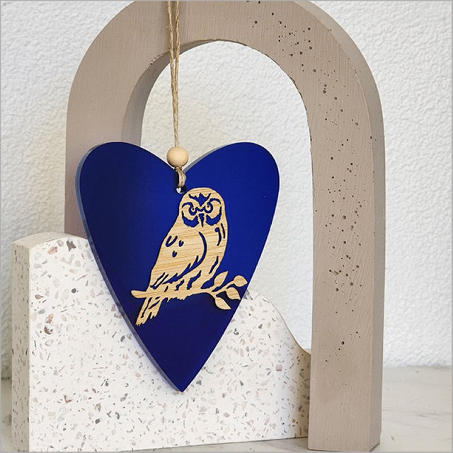 Heart-shaped hanging ornament in blue satin acrylic, crafted from laser-cut bamboo, perfect for stylish home decor.