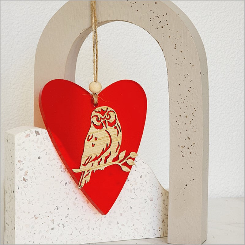Heart-shaped hanging ornament in red satin acrylic, crafted from laser-cut bamboo, perfect for festive decor and gifts.