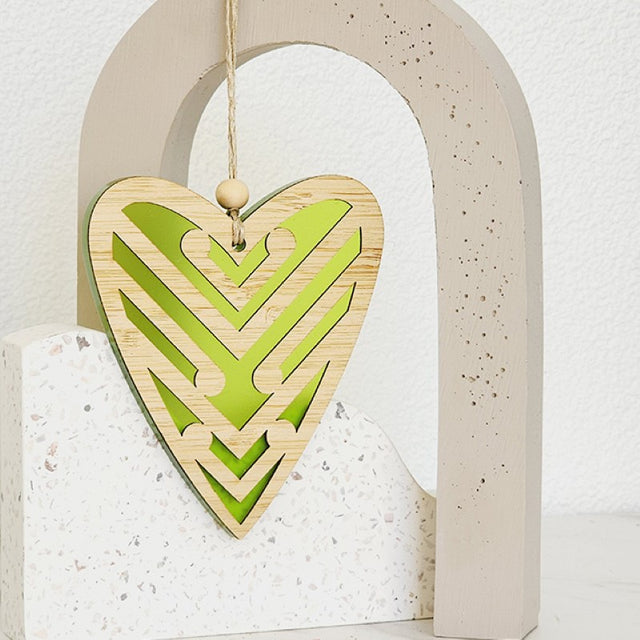 Heart-shaped hanging ornament in lime satin acrylic, featuring intricate Koru patterns, perfect for home decor and gifts.