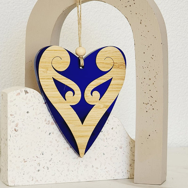 Elegant blue satin acrylic heart ornament with Koru patterns, perfect for decorating or gifting. Dimensions: 90mm x 105mm x 8mm.