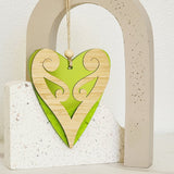 Lime satin acrylic heart ornament featuring a koru design, ideal for modern decor and eco-friendly gifting.