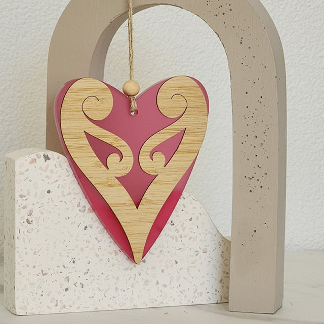 Pink satin acrylic heart ornament with intricate Koru design, symbolizing love and new beginnings, ideal for decor or gifting.
